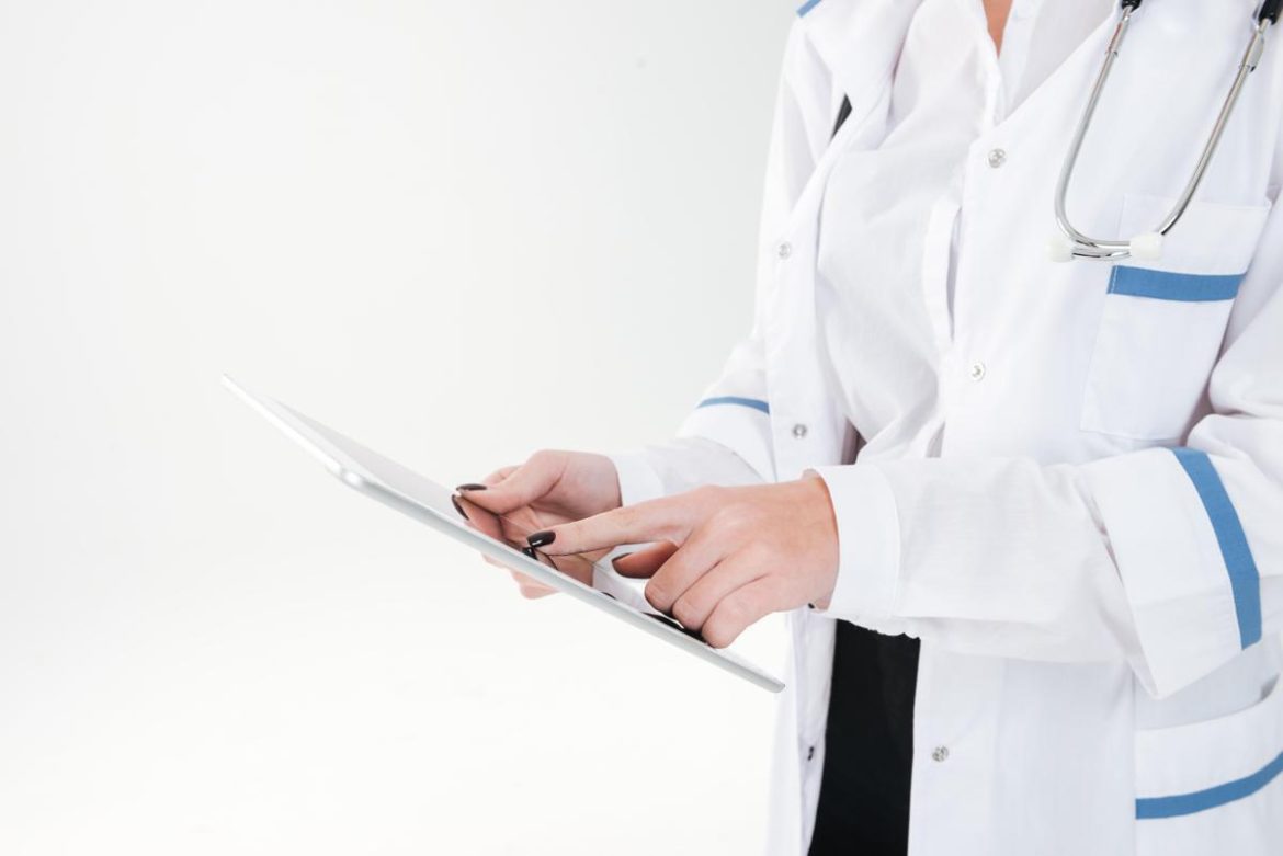 closeup-of-woman-doctor-standing-and-using-tablet-over-white-background-sbi-302848225.jpeg